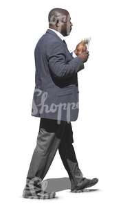 black businessman walking and looking at his tablet