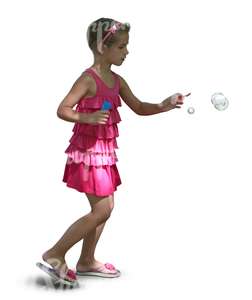 young girl in a pink dress playing with soap bubbles