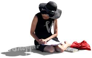 woman with a large hat sitting on the ground and reading