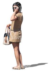 woman in a beige dress standing and looking at smth