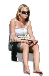 barefoot young woman with headphones sitting and listening to music