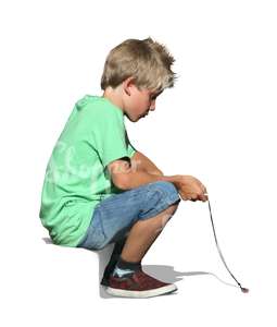 A young boy sitting on the sidewalk