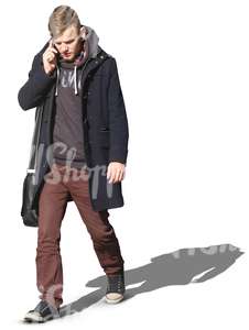 man in a black autumn coat walking and talking on the phone