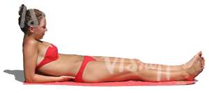 woman in a red bikini lying on the beach towel