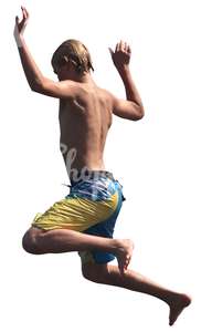 young boy in swimming shorts jumping into the water