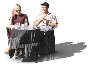 man and a woman sitting in a street cafe
