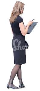 businesswoman in a black dress looking at her phone