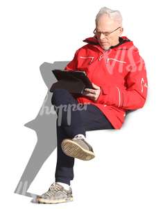 elderly man sitting and reading a tablet