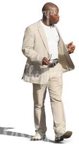 black man in a white suit walking