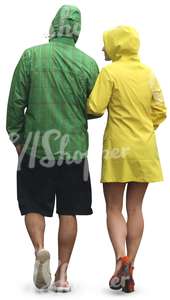 couple in colorul raincoats walking arm in arm