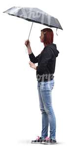 red-haired woman in jeans standing under an umbrella