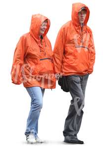 two people in orange raincoats walking hand in hand