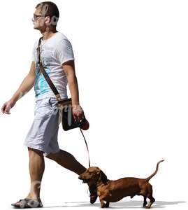 man in white shorts walking a dog