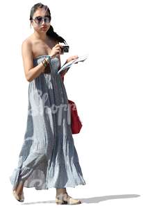 cut out woman in a long dress walking with a camera