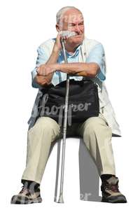 older man with a crutch sitting