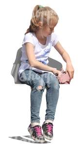 young girl sitting and looking in her handbag