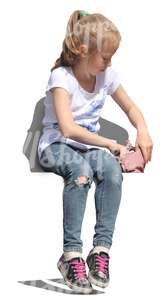 young girl sitting and looking in her handbag