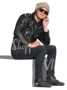 man in a leather jacket sitting and talking on the phone