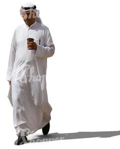 muslim man in a white thobe walking and drinking coffee