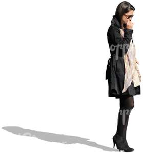 businesswoman in a black coat standing and thinking