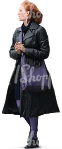 red haired woman in a black coat walking and talking