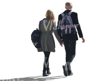 backlit couple walking hand in hand