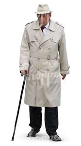 elderly man in a trenchcoat and hat walking