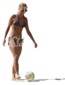 woman in a bikini playing ball on the beach