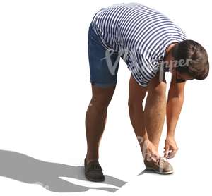 man in a striped shirt tying his shoelaces