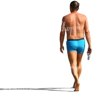 man in a bathing suit walking on the beach
