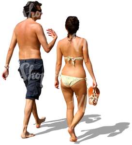 man and woman walking barefoot on the beach and talking