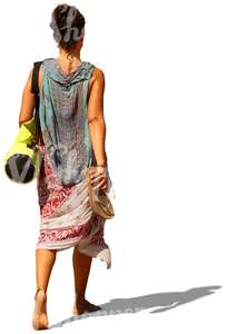 woman walking barefoot and carrying a yoga mat bag and sandals