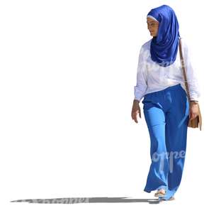 young muslim woman in a blue and white outfit walking