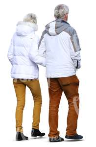 elderly man and woman wearing winter jackets walking