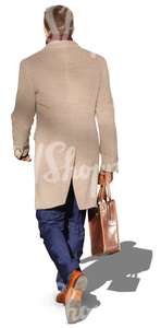 man in a beige coat walking with a suitcase