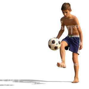 boy playing football on the beach