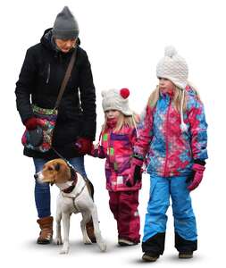 family with two children and a dog walking in wintertime