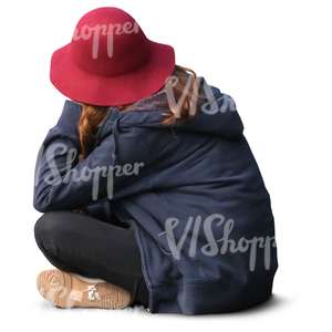 girl with a red hat sitting on the ground