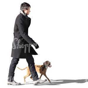 asian man in a black coat walking a dog