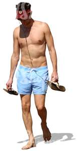 man walking barefoot on the beach and listening to music