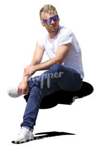 man wearing blue jeans sitting in the sun