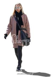 backlit woman in a pink coat walking