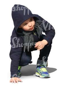 little boy squatting and looking up