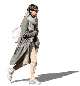 woman in a grey overcoat walking on a sunny day