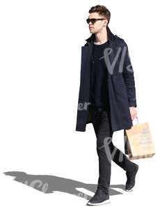 man wearing a black jacket walking with a shopping bag