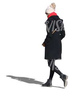 woman wearing a black coat and white hat walking