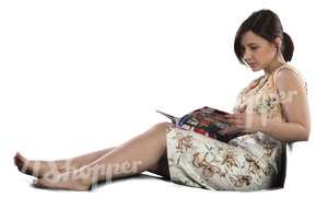 woman sitting on a couch and reading a magazine