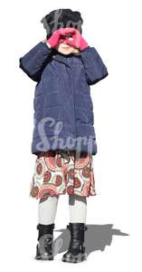 little girl wearing a winter jacket standing in the sunlight