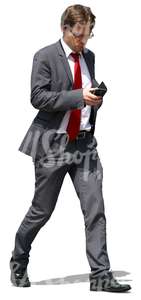 businessman walking and looking at his phone