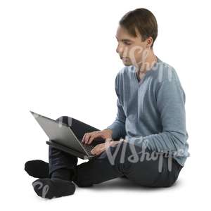 man sitting on the floor and working with a laptop